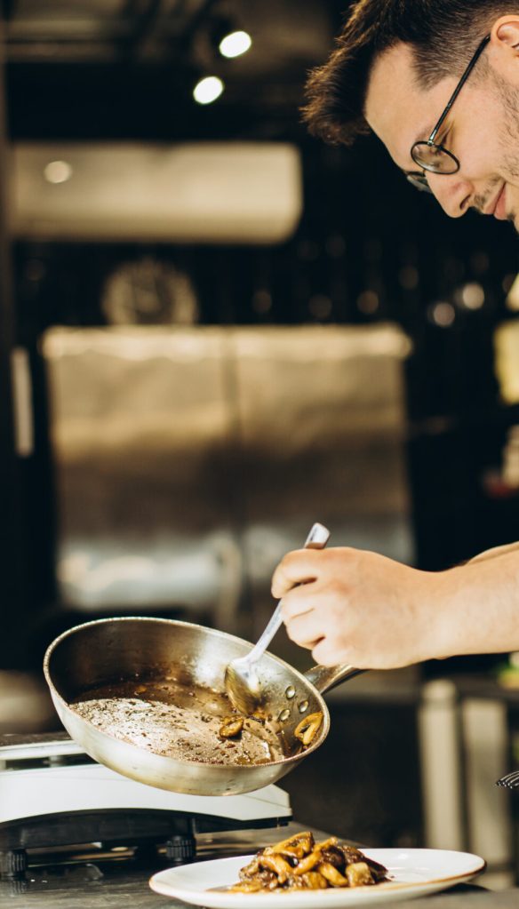 Man chef cooking asian chicken at a cafe kitchen